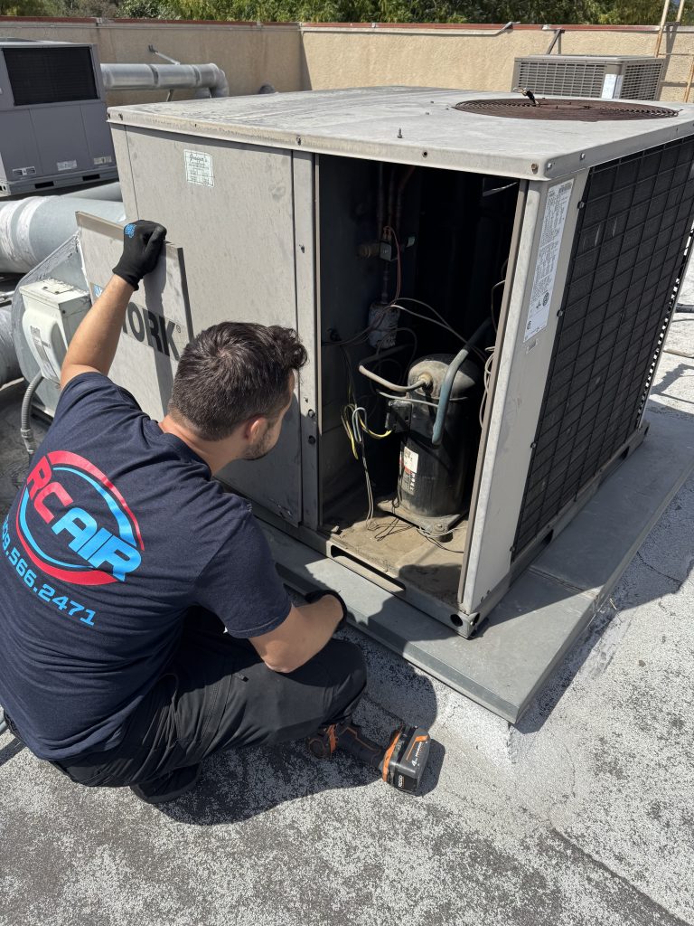Technician of RCAir Inspecting a rooftop HVAC Unit, determining the issue.