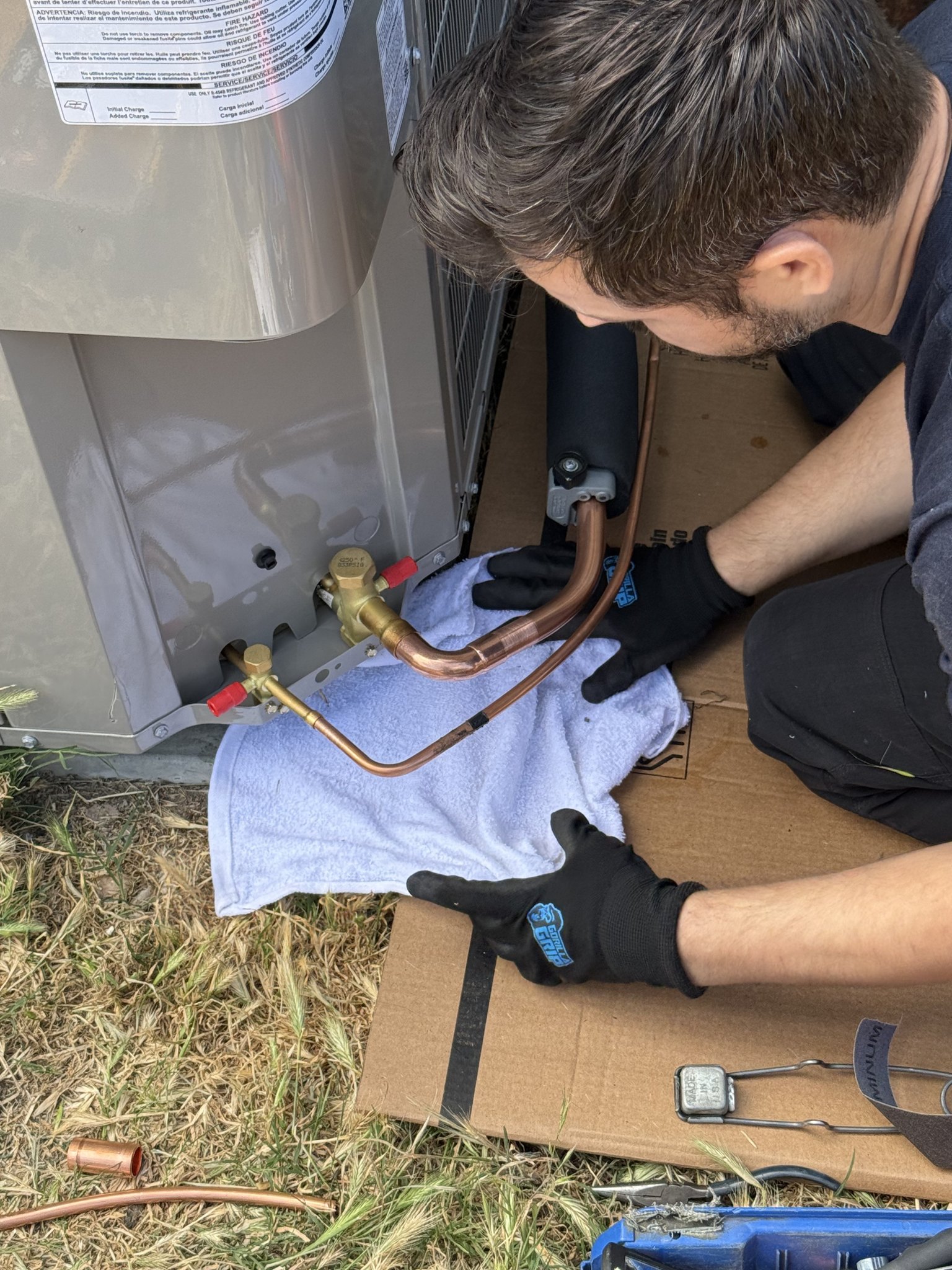 RCAir Tech working on the backside of a heatpump